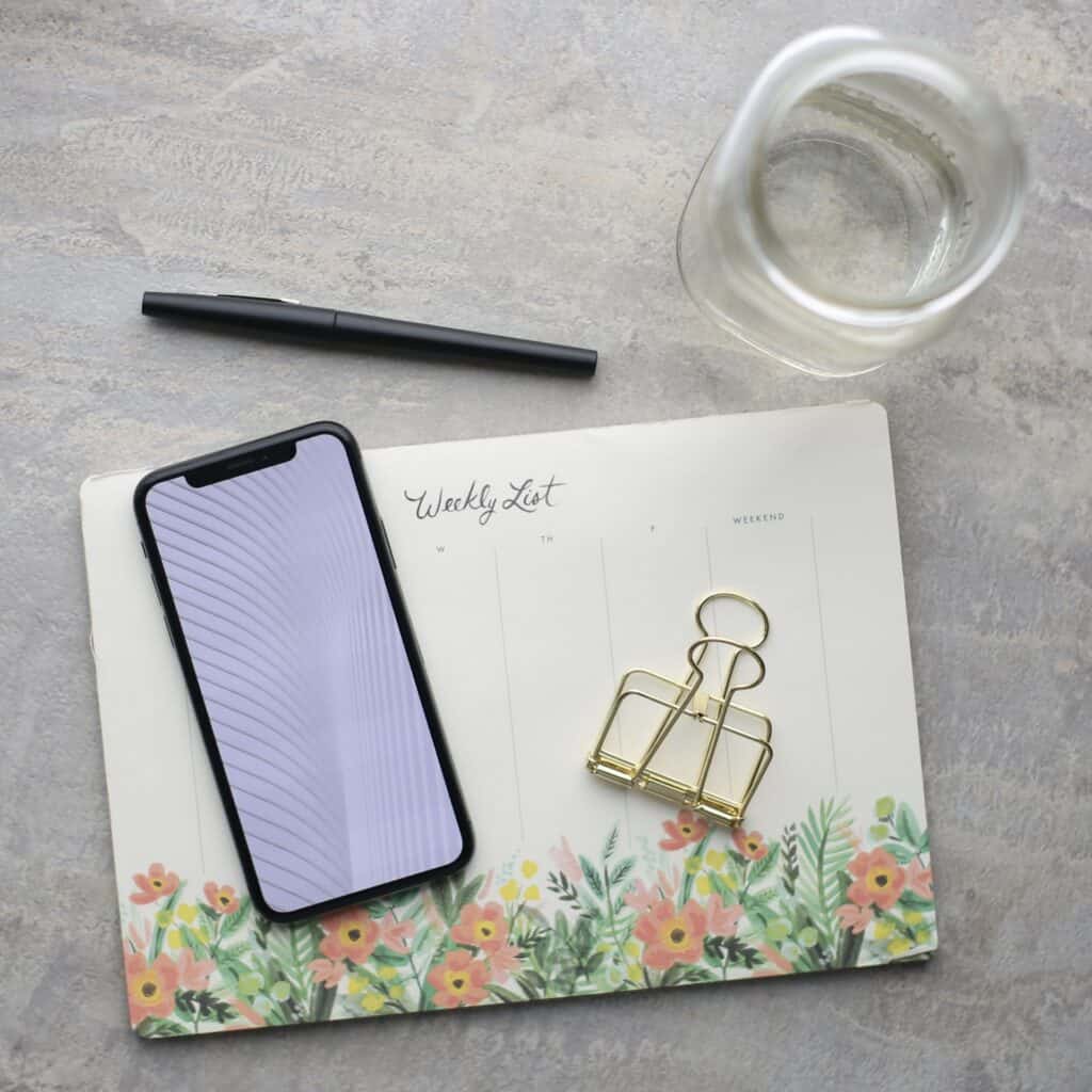cell phone, paper, pen, glass of water