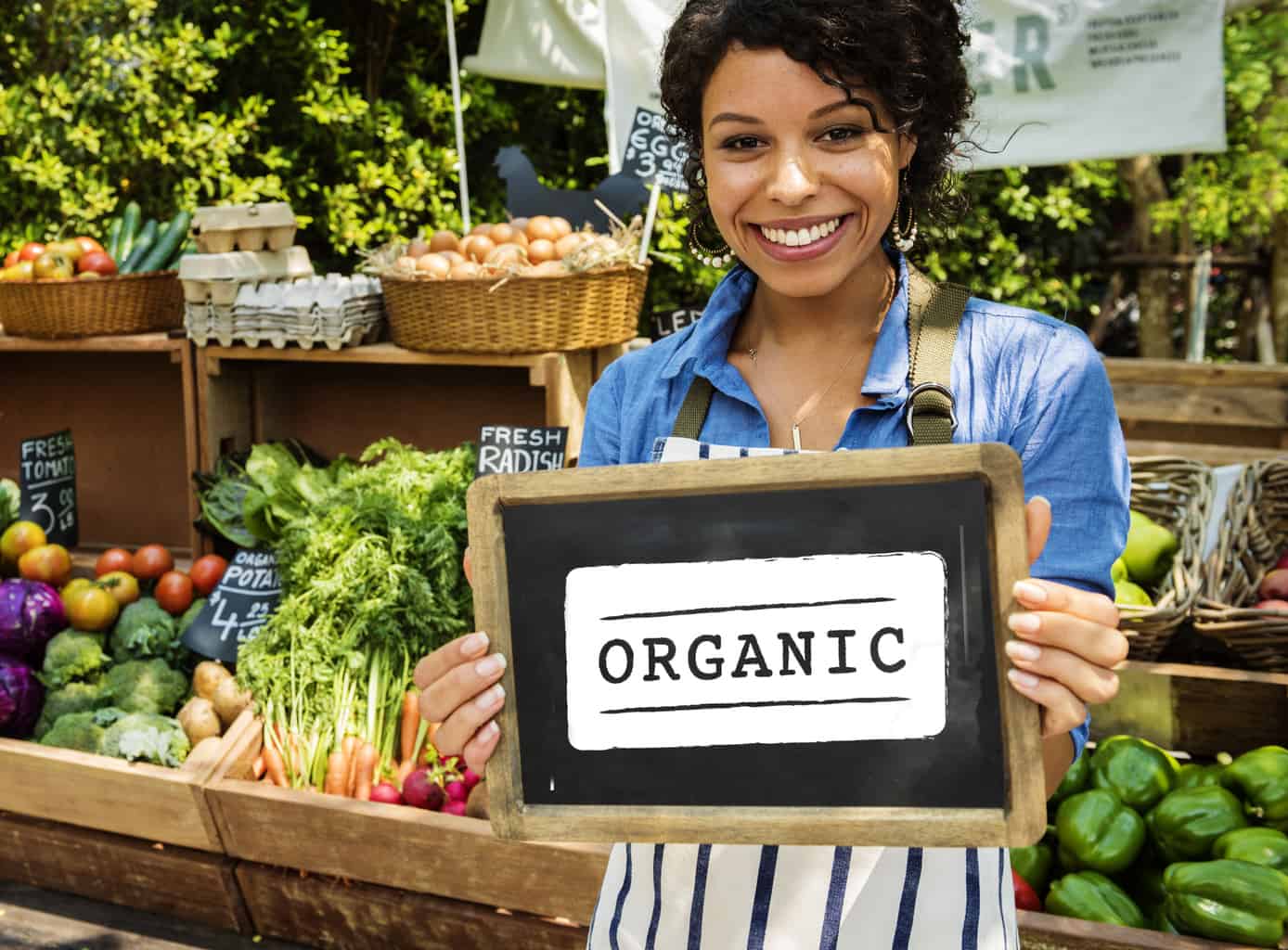 woman holding sign in front of organics